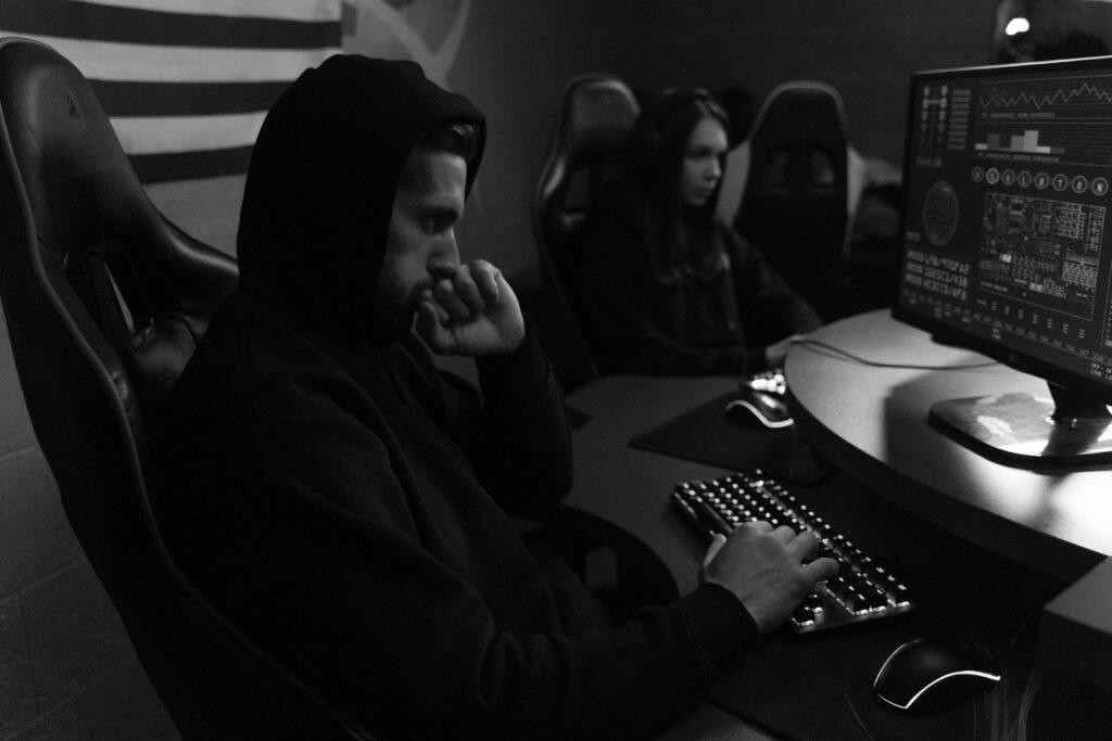pexels-photo-5380598-5380598 Two focused individuals analyze cybersecurity data on monitors, emphasizing digital protection strategies.